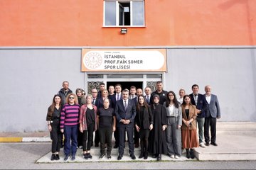 First image shows a man in a suit speaking at a podium in a large auditorium filled with seated audience members including teachers and officials with flowers on a table nearby. Second image depicts a group of men and women in formal attire standing on stage in front of a banner reading Sınav Üstünlüğü II with Turkish flags and portraits. Third image captures a group of students in black uniforms and a man in a suit standing in formation outdoors near school buildings under sunny skies. Fourth image features a diverse group of adults including men and women in professional clothing posing in front of an orange building entrance with a sign for Prof. Faik Somer Spor Lisesi.