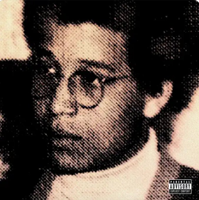 Black and white artistic portrait of a man with glasses looking sideways wearing a collared shirt against a plain background with a square logo in the bottom right corner