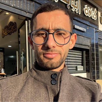 Four young children, two girls and two boys aged around 3 to 6, sit closely together on a bright yellow couch with green pillows in a room with beige curtains. The girl on the left wears a pinkish off-shoulder top with embroidery and blue pants, smiling with pigtails. Next to her, a red-haired boy in a white t-shirt looks thoughtful. Beside him, another red-haired boy in a dark blue polo shirt. The girl on the right wears a white top and pink pants, smiling with hair accessories. In the second image, a man in his 30s with short dark hair, glasses, and a trimmed beard stands outside a shop with blue walls and Arabic text including numbers 05940575, wearing a gray collared jacket, with warm lighting and decorative elements.