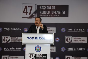 First image shows a man in a suit speaking at a podium with banners reading 47 Baskanlar Kurulu Toplantisi 23-26 Eylul Antalysi and TOC BIR-SEN logos on a stage backdrop. Second image depicts a conference room with attendees seated at round tables under ceiling lights facing a stage with Turkish flags and TOC BIR-SEN signage. Third image captures a man in a suit gesturing from behind a podium in a room with projected screen overhead lights and audience seated at tables with Turkish flags on walls. Fourth image features a large group of people standing together in formal attire in front of a stage with TOC BIR-SEN banners Turkish flags and event signage.