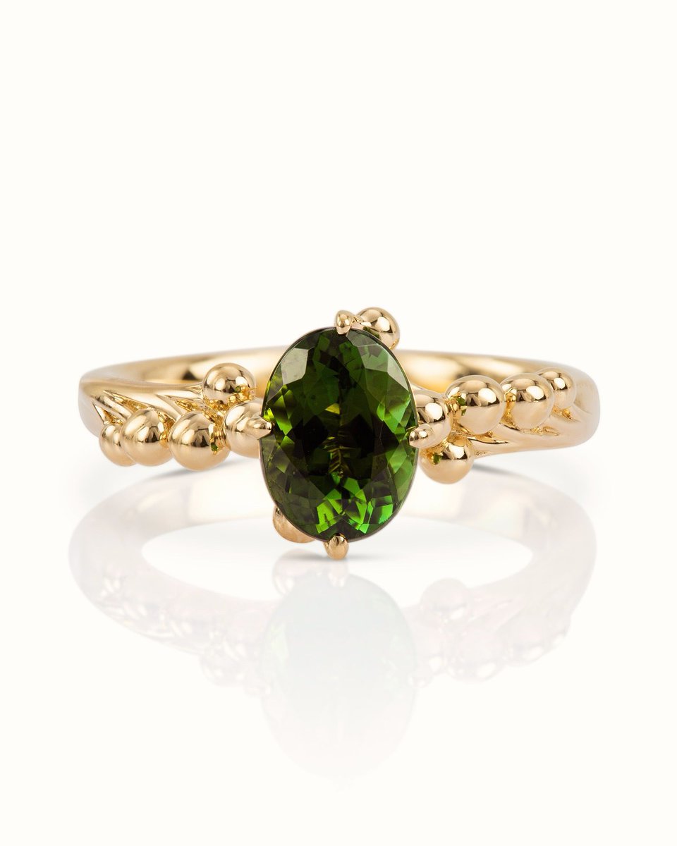 October Tourmaline... Tourmaline is now a popular #OctoberBirthstone .  This ring centres on a striking green tourmaline, its shimmering oval form, captured within hand-formed 18ct gold elements. Flowing detailing continues gently along the shoulders towards the jewel.