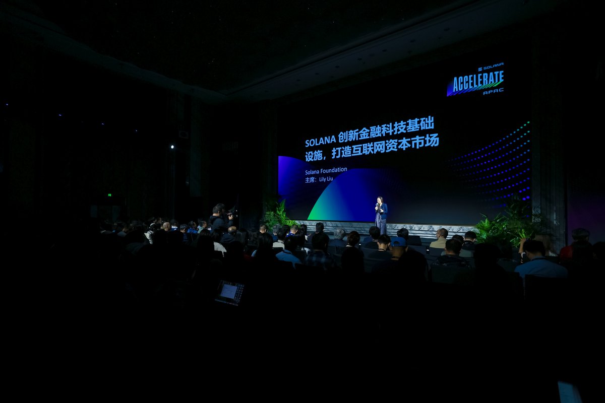 Lily Liu 在上海 Solana Accelerate APAC 上发表演讲，舞台充满活力，观众专注聆听