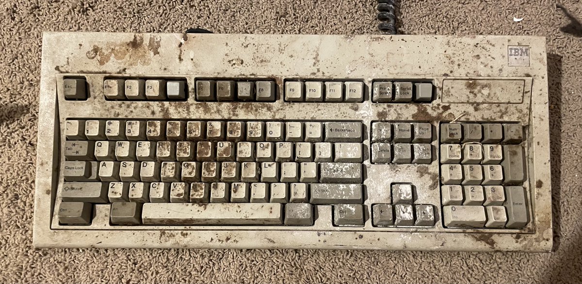 usrbinsean's tweet image. A genuine "barn find" of vintage technology.  
I found a genuine  IBM Model M covered in about 30 years of grime, dust, and mold sorting out my storage unit.  
Its friend that fell down a flight of concrete stairs and offers spare parts is somewhere nearby.