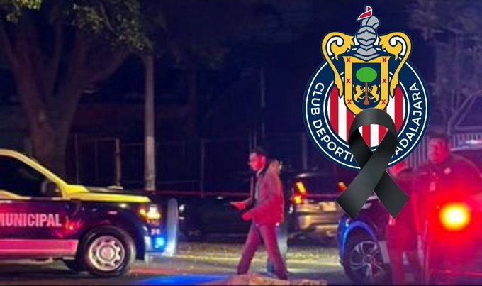 Nighttime urban street scene at an intersection with yellow and pink police vehicles parked, their emergency lights flashing blue and red. A man in dark hoodie and pants walks away from the vehicles toward the camera. Another vehicle with lights is visible in the background. Chivas soccer club emblem with green, blue, and yellow colors and a black ribbon overlay is superimposed on the upper right.