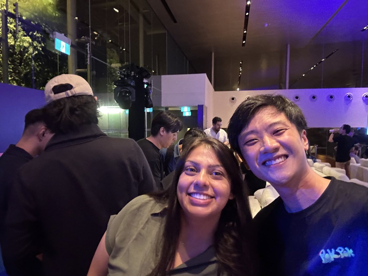 混雑したカンファレンス会場で自撮りする二人