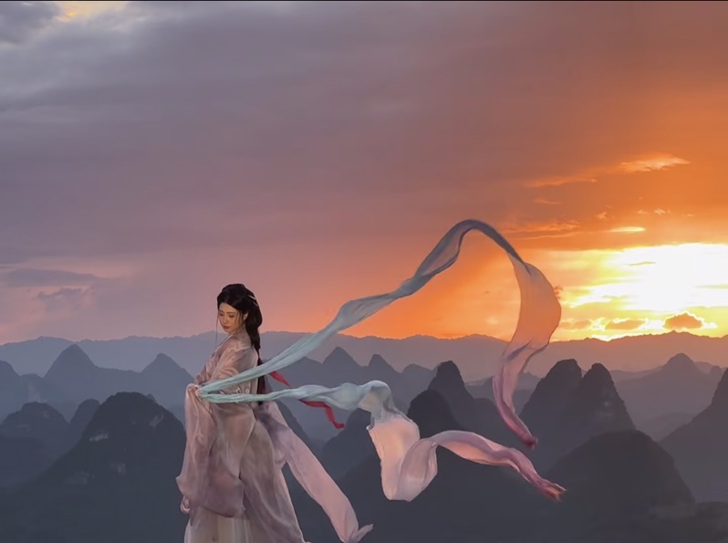 Exploring the enchanting karst landscapes of #Yangshuo in #Guilin as the sunset illuminates the scenery. Blogger Lulu gracefully adorned in a light pink #Hanfu with silk Hanfu shawl, bringing the essence of traditional Chinese art to life.  (Via.ShiJianCangBuZhuLuLu)