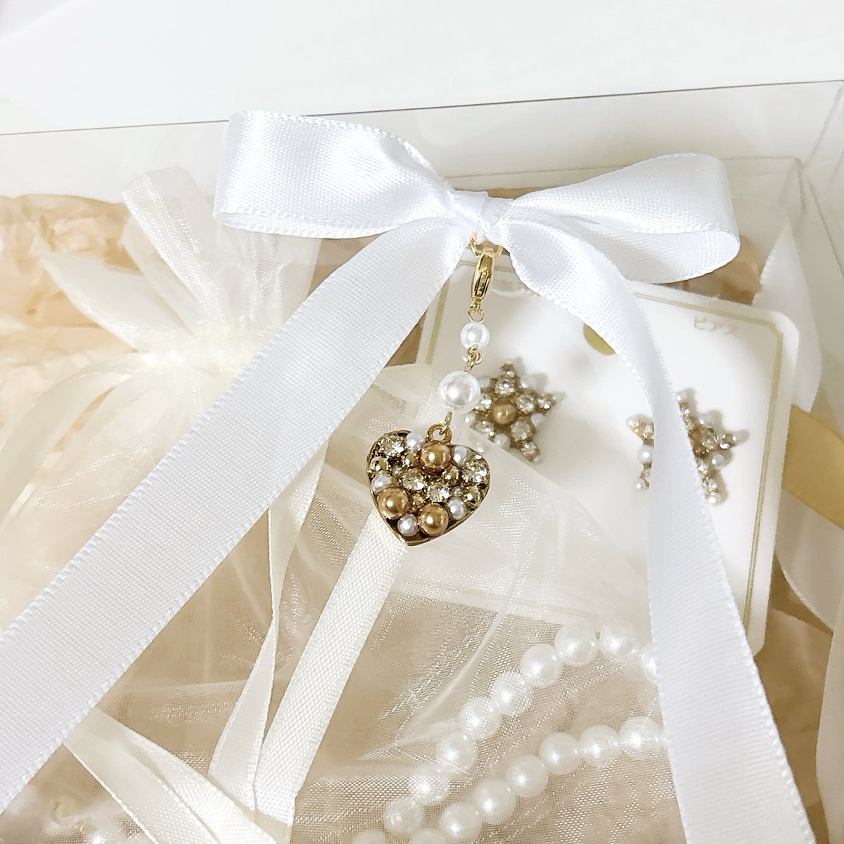 チャームも作りました🎀

箱の外側にラッピングすると
厚さ制限を超えてしまう…(3cm)

ならクリアボックスの中にリボンを入れたら
華やかさも諦めず
厚さも超えないのではと思いつきました。

そしてただのリボンより
チャーム付きなら可愛いのではと！