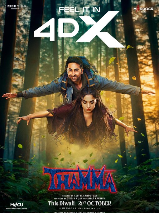 Promotional poster for the movie Thamma featuring actors Ayushmann Khurrana and Rashmika Mandanna in a forest setting with green foliage and sunlight filtering through trees. Ayushmann Khurrana, dressed in a blue jacket, carries Rashmika Mandanna on his back as she extends her arms outward wearing a maroon top. The title Thamma is displayed in large blue and red letters at the bottom, with production credits for Maddock Films and UV Creations, and release date This Diwali 21st October. Text overlay reads Feel it in 4DX.