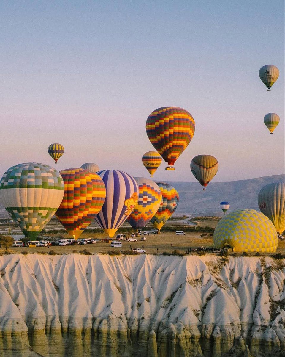 GoTurkiye's tweet image. Float over Cappadocia’s otherworldly landscapes as hot air balloons drift across the sky, adding a splash of colour to its timeless scenery. #Cappadocia