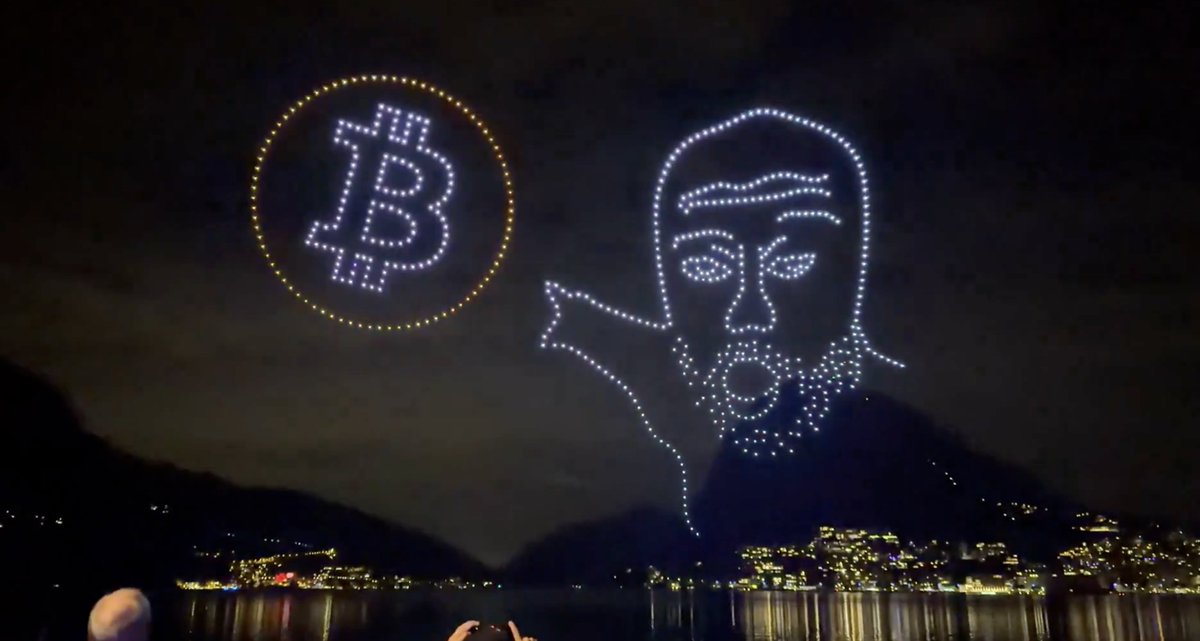 루가노 하늘에 드론으로 형성된 비트코인 심볼과 Peter Schiff 얼굴
