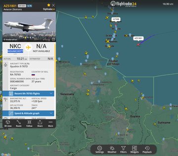 First image displays Flightradar24 interface with map tracking white Il-76TD aircraft registration RA-78765 callsign AZS1801 flying over Atlantic near Venezuela Guyana Suriname with details on departure from Nouakchott Mauritania speed 102 ELM altitude graphs recent flights and filters. Second image shows white Russian Il-76TD cargo plane registration RA-78765 with red tail stripes Russian flag on fuselage in flight over gray sky with urban buildings palm trees and towers below landing gear extended.