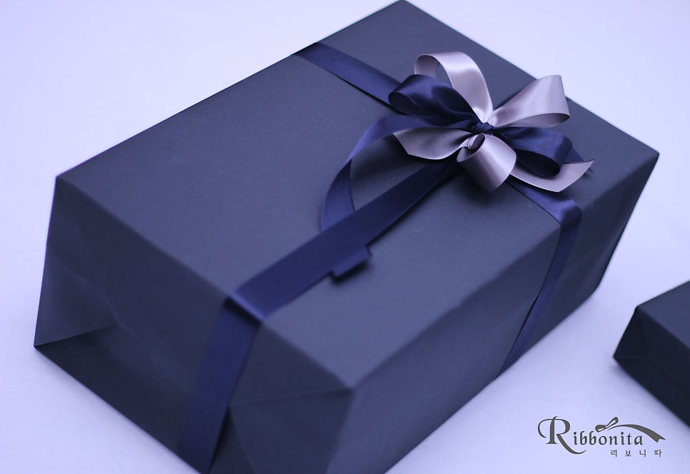 오는 11월 7일부터 2026년 1월 11일까지 공연될 뮤지컬 <#에비타>에서 '체' 역에 캐스팅된 뮤지컬 배우 #민우혁 님의 생일을 맞아 팬분께서 축하 선물을 마련해 리보니따를 찾아주셨어요. 선물포장 컨셉은 블랙 포장지에 네이비와 연그레이 리본으로 장식을 해드렸어요.m.blog.naver.com/chmik10/224052…