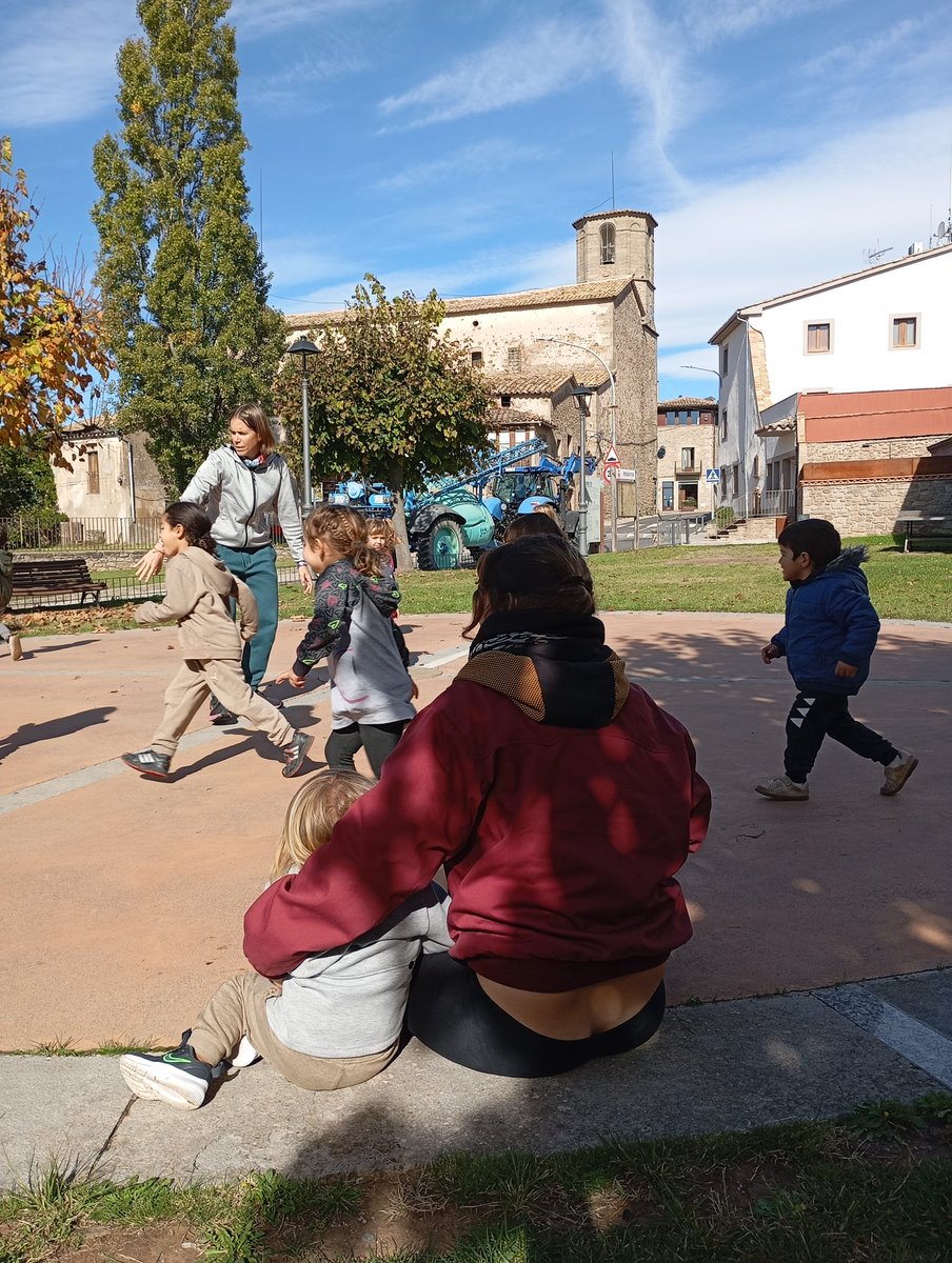 A la plaça del poble, els infants del grup de Petits i els de l'escola bressol Petit Heurom, assaig de la dansa conjunta que faran divendres a la Castanyada de <a href="/Ajunt_Perafita/">Ajuntament de Perafita</a>