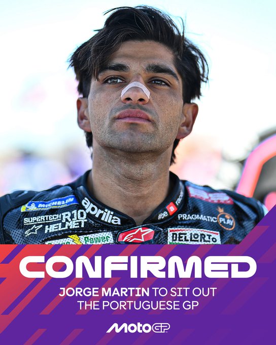 A young man with dark hair and a mustache wearing a black racing suit adorned with sponsor logos including Aprilia, Dainese, and Pramac, stands with a serious expression, a white nasal strip on his nose, against a blurred outdoor background with people and barriers, overlaid bold purple text reading CONFIRMED Jorge Martin to sit out THE PORTUGUESE GP with MotoGP logo.
