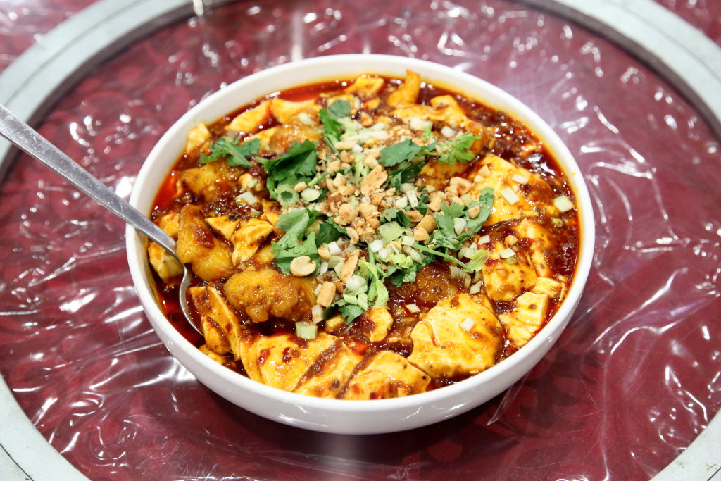 Pork ribs with garlic are a chef's special, buried at the very bottom, on the menu of Hot Kitchen Sichuan Style in Flushing, Queens. There's no reason they can't be an appetizer! Also shown: wontons in hot oil, sautéed pea sprouts, and fish filets with bean curd sauce.