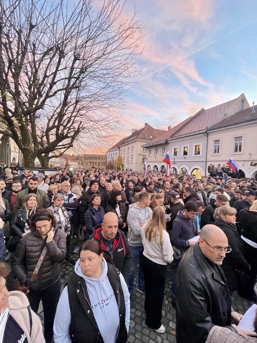 Ljudje na trgu prek velikega ekrana v živo spremljajo izredno sejo mestnega sveta. Med govorom župana Macedonija večkrat huronski aplavz množice, ki vzklika: Aco, Aco … <a href="/vecer/">Večer</a>