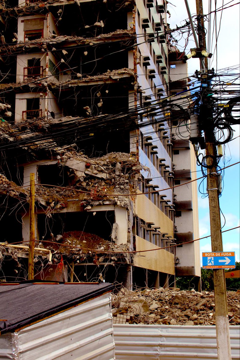 ctdfotografico's tweet photo. Entre as ruínas, fios se entrelaçam como cicatrizes do que restou, e a placa “rota de fuga” parece apontar um caminho que já não existe. https://t.co/AjgyWXQUyq