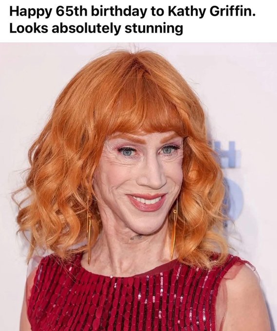 Kathy Griffin smiles with red wavy hair, blue eyes, wearing gold hoop earrings and a sparkling red dress.