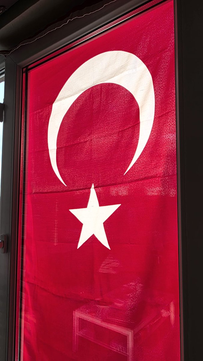 Hep bayram sabahlarının heyecanıyla büyüdük ya biz…
O sabahlar başka olurdu.
Ev daha gün doğmadan uyanır, mutfaktan mis gibi çay kokusu yayılırdı. Annemin sesi yankılanırdı koridorda:
— Arif, bayrağı astın mı?
— Astım Semra, astım… Dün akşamdan astım.
O diyalog hiç değişmezdi.