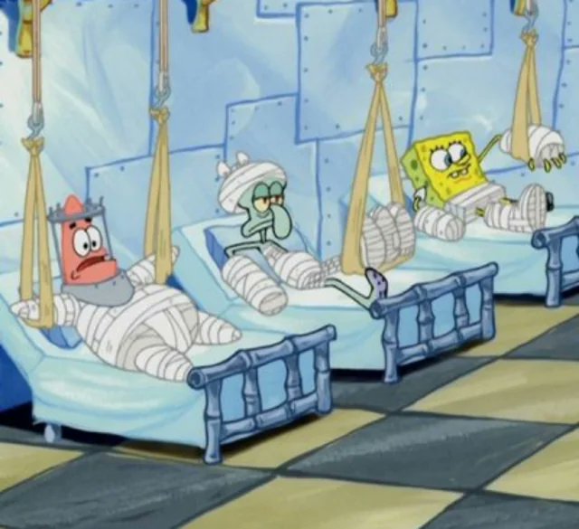 SpongeBob SquarePants characters including Patrick Star with a crown and bandages on his head and body lying on a bed, SpongeBob with bandages on his arms and legs also on a bed, and Squidward with bandages on his head and one leg on another bed, all in a blue and green hospital room setting with checkered floor.