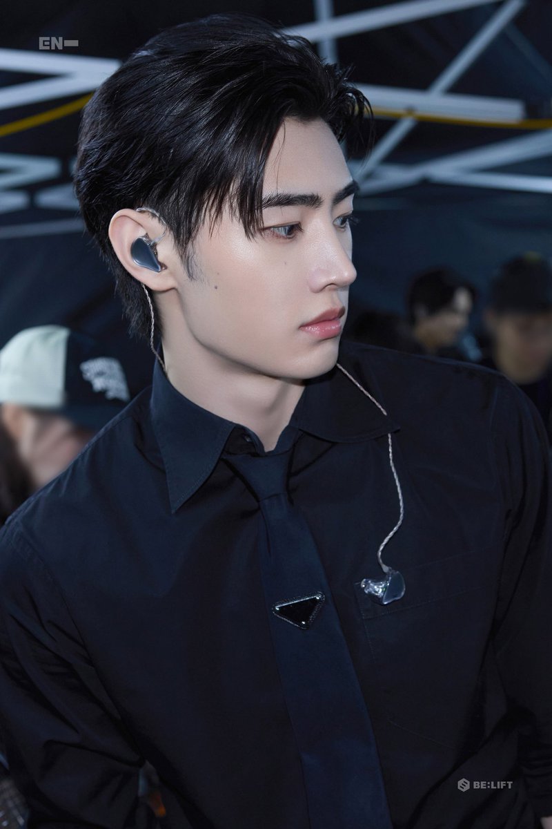 Sunghoon’s black outfit exudes his ambassadorial poise, announced May 2025, while his earpiece showcases ENHYPEN’s tour prep for the 38-show Walk the Line: Final, blending athletic grace backstage.