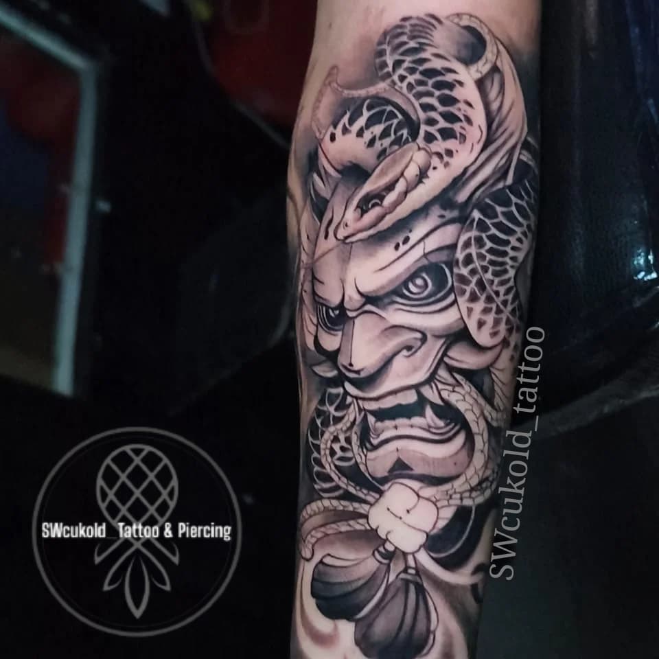 Diseño en negro y gris con gran detalle y fuerza visual.
La máscara Oni representa la protección frente a las energías negativas y la capacidad de enfrentar los propios miedos.
La serpiente simboliza sabiduría, transformación y la habilidad de adaptarse ante los desafíos.

Ambos