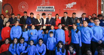 First image shows a man in a suit standing at a podium speaking with a microphone in front of a large red banner displaying TTF Istanbul Tenis Merkezi logo and Turkish Tennis Federation branding surrounded by sponsors like Spor Toto and attendees seated in blue uniforms. Second image captures a group ribbon-cutting ceremony with officials including men and women in formal attire and children in red and blue tracksuits smiling and holding scissors in front of a similar red banner with tennis racket graphics. Third image features a close-up of the minister in a suit embracing and interacting with children in blue uniforms near a tennis net setup against the branded backdrop. Fourth image is an aerial view of the tennis facility with multiple red clay courts stands lighting poles surrounding greenery an indoor dome structure and nearby urban buildings with sea in the background.