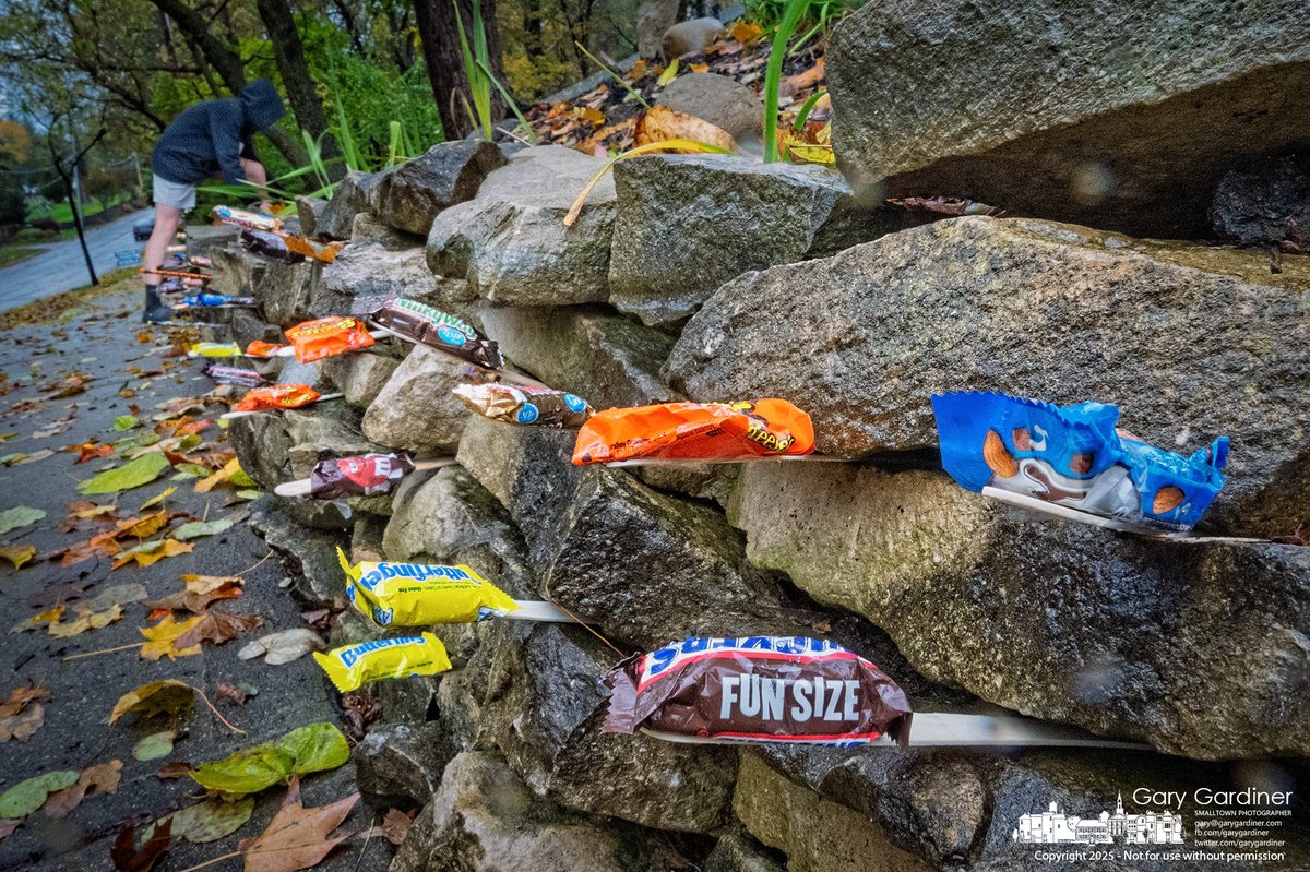 One family found a creative way to hand out Halloween candy by placing it in the gaps of a stone wall along the sidewalk in front of their home. My Final Photo for October 30, 2025. rebrand.ly/mfp103025