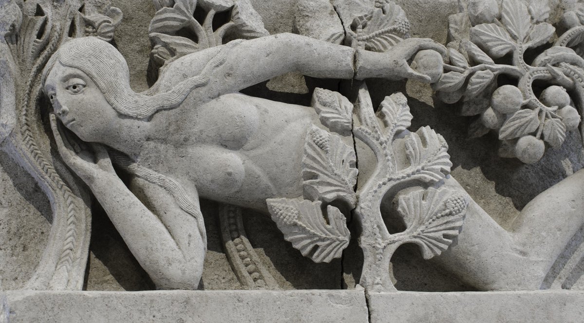 LA TENTATION D'ÈVE. Attr. Gislebert, fragment de linteau provenant de la cath. St-Lazare, c. 1130 - Musée Rolin, Autun. Eve cache partiellement sa nudité derrière un cep de vigne qui, selon certains auteurs, pourrait symboliser sa descendance, l'humanité.
musee-virtuel-vin.fr/sculpture
