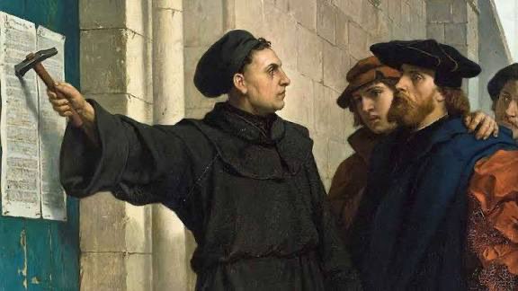 Orsatramola's tweet photo. Martin Luther, 508 yıl önce bugün yani 31 Ekim 1517’de Almanya'da Katolik Kilisesi’ne karşı, 95 maddeden oluşan protesto bildirisini Wittenberg Şatosu Kilisesi’nin kapısına astı ve bilinçli olmasa da aklın özgürleşmesine neden olacak uzun, sancılı ve kanlı bir süreci başlatmış oldu.

Aynı yıl, Türklerin Anadolu’da ve Balkanlar’da yarattığı hoşgörülü ve aklı yok saymayan İslam anlayışını yok edecek sürecin tetiğine de Yavuz Sultan Selim’in Hilafetle beraber Mısır'dan getirdiği ulema ile basıldı.

Martin Luther'in başlattığı hareket Hristiyan dünyayı böldü ve Protestanlık mezhebinin doğmasına neden oldu ama Avrupa'da aile, evlilik, eğitim, bilim, sosyal düzen, ekonomi ve sanat da dâhil yaşamın tüm yönlerini etkiledi.

Reformcular kaynak olarak sadece kutsal kitap İncil’i kabul ettiklerini, kutsal kitabı yorumlamanın sadece kilisenin değil herkesin hakkı olduğunu, kutsal bir dil olamayacağını, İncil'in her dilde basılıp okunabileceğini, Tanrı tarafından insana bahşedilen akıl ve niteliklerin özgürce kullanımının önünün açılması gerektiğini ve birçok dinsel ritüelin gereksiz olduğunu ortaya koydular. 1534’de İncil, Almanca olarak basıldı. Daha sonra İngilizce dâhil, başka dillerde de basıldı ve böylece kendi dilinde İncil’i okuyan halk, din adamlarının sömürüsüne karşı örgütlenmeye başladı.

Dünyanın dördüncü ve Avrupa'nın bir numaralı ekonomisi olan Almanya, bulunduğu yere tesadüfen gelmedi. Hatta II.Dünya Savaşı sonunda yerle bir edilmiş olan, taş taş üstünde bırakılmayan Almanya kısa sürede toparlandı ve bugünkü durumuna geldi. Nedeni insan malzemesinin iyi olmasıydı.

Almanya; monarşinin (tek adam yönetimi) ve teokrasinin yıkılmasında, sanayi devrimine giden yolun açılmasında, eğitimin çok önemli hale gelmesinde, akılcı ve bilimsel düşünce evresine geçişte ve insan aklının özgürleştirilmesinde çok önemli ve belirleyici rolü olan dinde reform hareketinin başladığı yerdi.