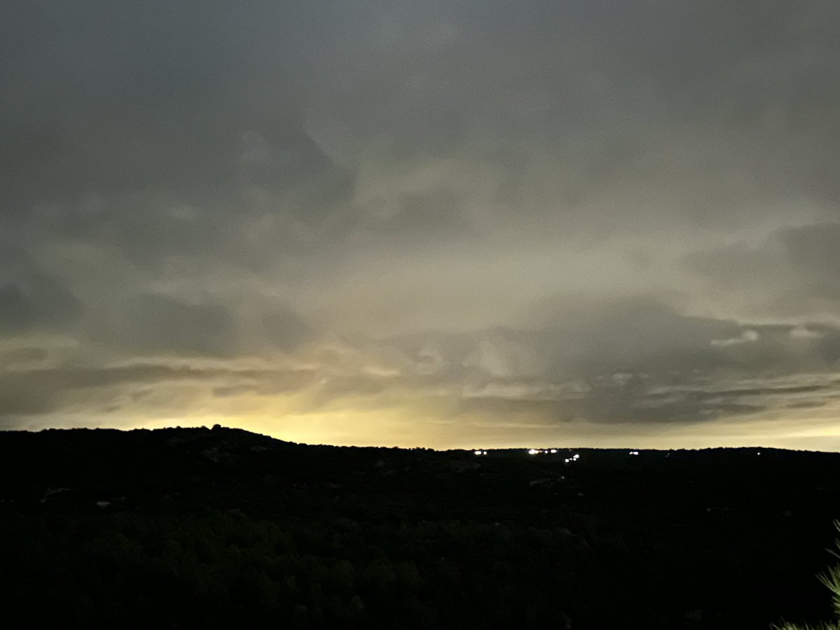 Noche cerrada. Solo el resplandor de las luces de El Escorial, tras los montes, a la izquierda de la imagen, sugieren una zona poblada con actividad.