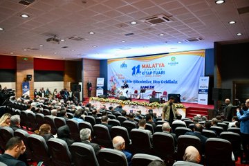 First image shows a large group of adults and children standing together in formal and traditional clothing. Several men wear suits and ties, some with Turkish flags on lapels. Women in headscarves and dresses. Children, appearing under 10 years old, dressed in colorful traditional Anatolian outfits with embroidered vests, skirts, pants, and headpieces in red, blue, and gold. They stand in front rows smiling at camera. Background is plain indoor setting. Second image depicts a man in suit and glasses holding a microphone at a podium surrounded by multiple microphones from media outlets including TRT and CNN Turk logos. Bottles of water on the stand, blue banner behind with event text. Third image captures a conference hall stage with banners reading 11 Malatya and Kitap Fuarı. Audience seated in chairs, people on stage including men in suits, flowers on tables, projector screen, and flags.