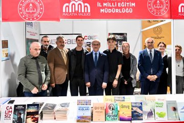 First image shows a large group of officials and attendees in formal attire standing together cutting a red ribbon at the entrance of a spacious tent venue decorated with numerous Turkish flags hanging from the ceiling and walls, with a prominent banner reading Malatya Anadolu Kitap Fuarı Bir Kitap in the background. Second image depicts several men in suits gathered around a display table covered with various colorful books, some holding books with blue covers, positioned in front of a booth with digital screens and promotional materials. Third image features a diverse group of people including men and women in business attire standing behind a table laden with stacks of books at a booth labeled with red banners for Milli Egitim Malatya Valiligi Mudurlugu, surrounded by educational signage. Fourth image captures an elderly woman in a dark hijab and long coat standing with a man in a blue suit and glasses, accompanied by a young girl in a white dress and three young boys in casual clothes holding items, all posing in front of bookshelves in an exhibition hall setting.