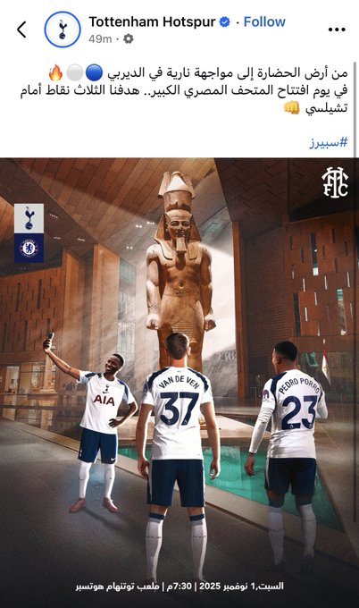 Three Tottenham Hotspur soccer players in blue and white uniforms with numbers 37 and 25 stand in front of a tall ancient Egyptian statue resembling a pharaoh in a museum hall with stone walls and floor. One player holds a phone for a selfie while the others pose with arms raised. Arabic text overlays the bottom part reading something about Tottenham and a date in 2023. The Tottenham logo appears on the players jerseys.