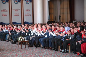 Stage setup with green backdrop displaying Arabic text quotes and white decorative borders man in suit and cap seated at table with microphone another image shows blue stage with 20 Turkiye Bulusmasi banner flags podium with Mesut oner text man in red white vest speaking at podium with flowers below third image depicts row of formally dressed men and women some in vests headscarves seated in auditorium with banners for Istanbul Adana Adiyaman branches and Turkish flags fourth image shows similar group of attendees clapping hands raised in applause with banners for Istanbul Adana Adiyaman branches flowers on table.