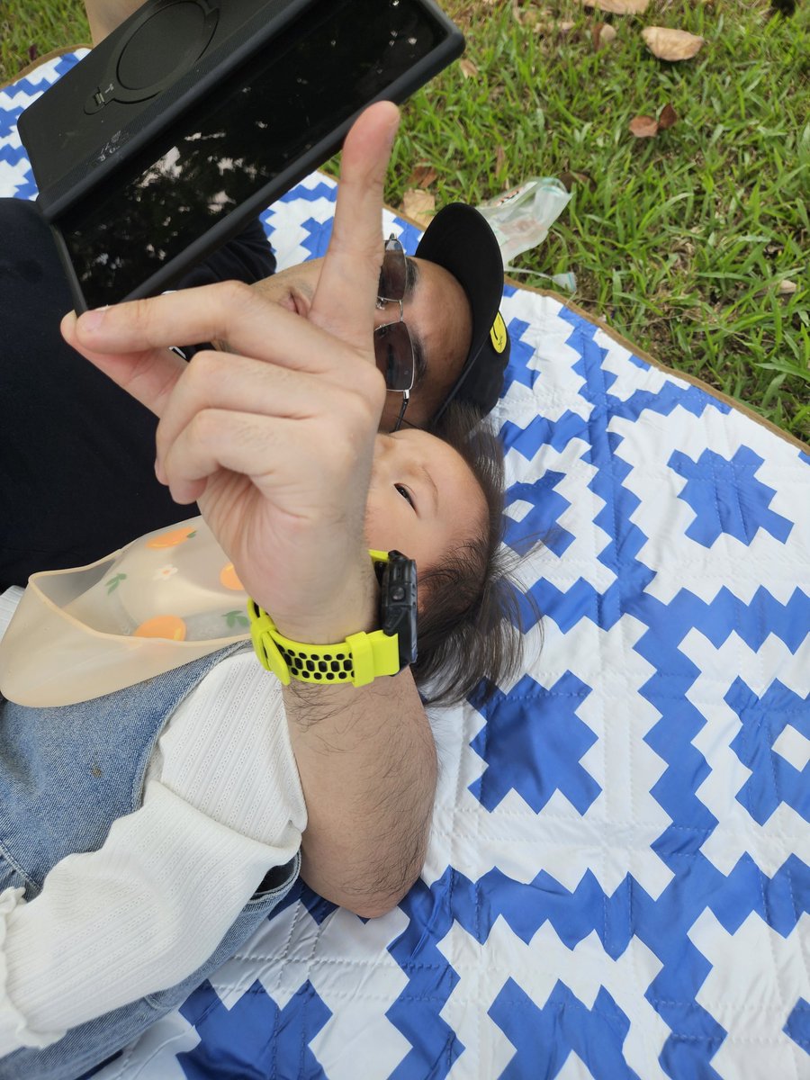 和葫芦娃躺在草地上看手机。