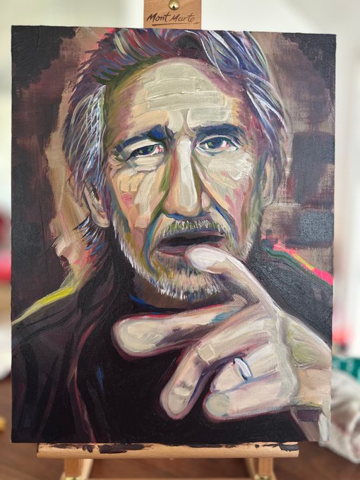 Portrait of Roger Waters on canvas with easel, showing an older man with gray hair, thoughtful expression, finger touching lips, dark expressive brushstrokes in oil paint, Mont Marte brand visible on easel.