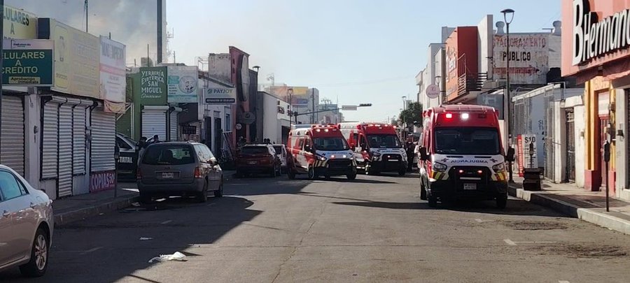 First image displays the official seal of Sonora's General Prosecutor's Office for Justice on a press information document detailing the fire investigation at Waldo's store including hypotheses of accidental causes due to a transformer and pending access for cause determination after debris removal. Second image captures a street scene in Hermosillo with multiple red fire trucks parked along a commercial area showing smoke rising from buildings storefronts like Farmacias and Bar none with emergency vehicles positioned for response and some civilian cars nearby under clear daytime skies.