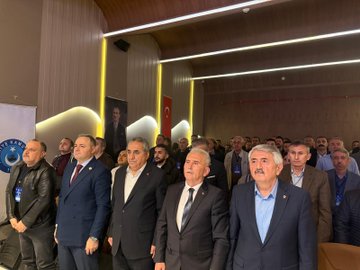 First image shows a man in a suit speaking at a podium with arms raised, wearing glasses, surrounded by red and white flower arrangements and banners reading TÜRKİYE KAMU-SEN and TÜRK BÜRO-SEN, with a blue screen in the background and another person partially visible nearby. Second image depicts a large audience of men and women in formal attire seated in a dimly lit hall with yellow lighting, wooden walls, a Turkish flag, and a banner on the side. Third image features four men in suits seated at a table on stage, one holding a microphone, with nameplates like BAŞKAN and name cards including BASAR VE BÜRO-SEN, against a screen displaying Türk Büro-Sen Istanbul 3 Nolu Sube Olağan Kongresine Hos Geldiniz. Fourth image shows a group of about 20 men in suits standing together in a hall with curved ceilings, yellow lighting, a Turkish flag, and a banner with a circular emblem.