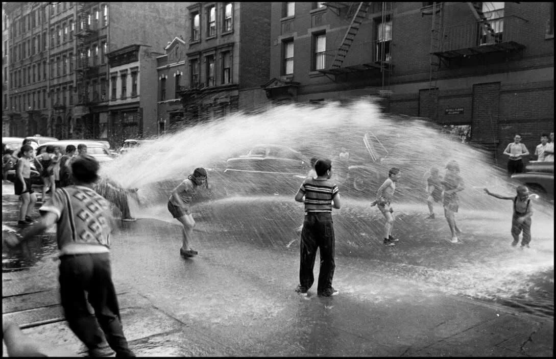 Happiness coming out of a fire hydrant. New York, 1953  |  Elliott Erwitt