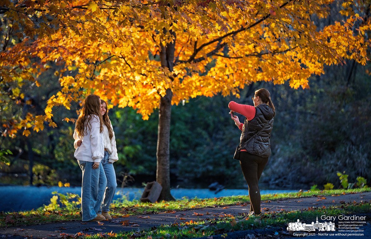 Best friends pose for a photo taken with a point-and-shoot digital camera by the mother of one of them, framed by the golden colors of fall at the Alum Creek Park North Dam. My Final Photo for November 2, 2025. rebrand.ly/mfp110225