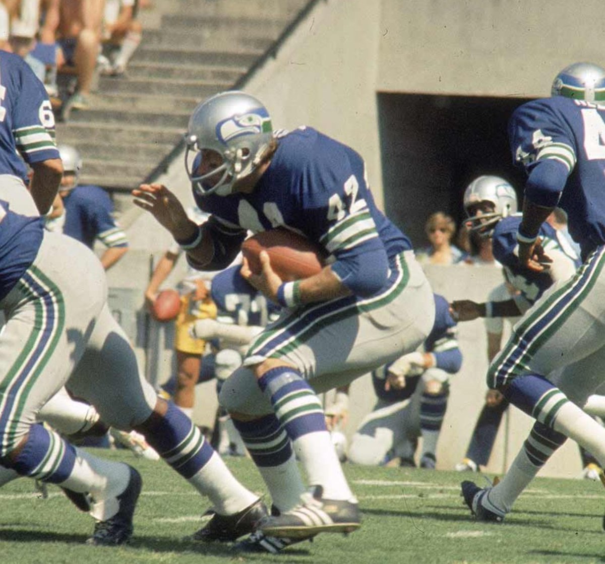 Inaugural Seahawks in 1976. Started with a gray mask and traditional sleeve stripes without the helmet logo.