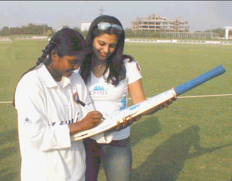 Neetu David autographing a bat for Mandira Bedi.