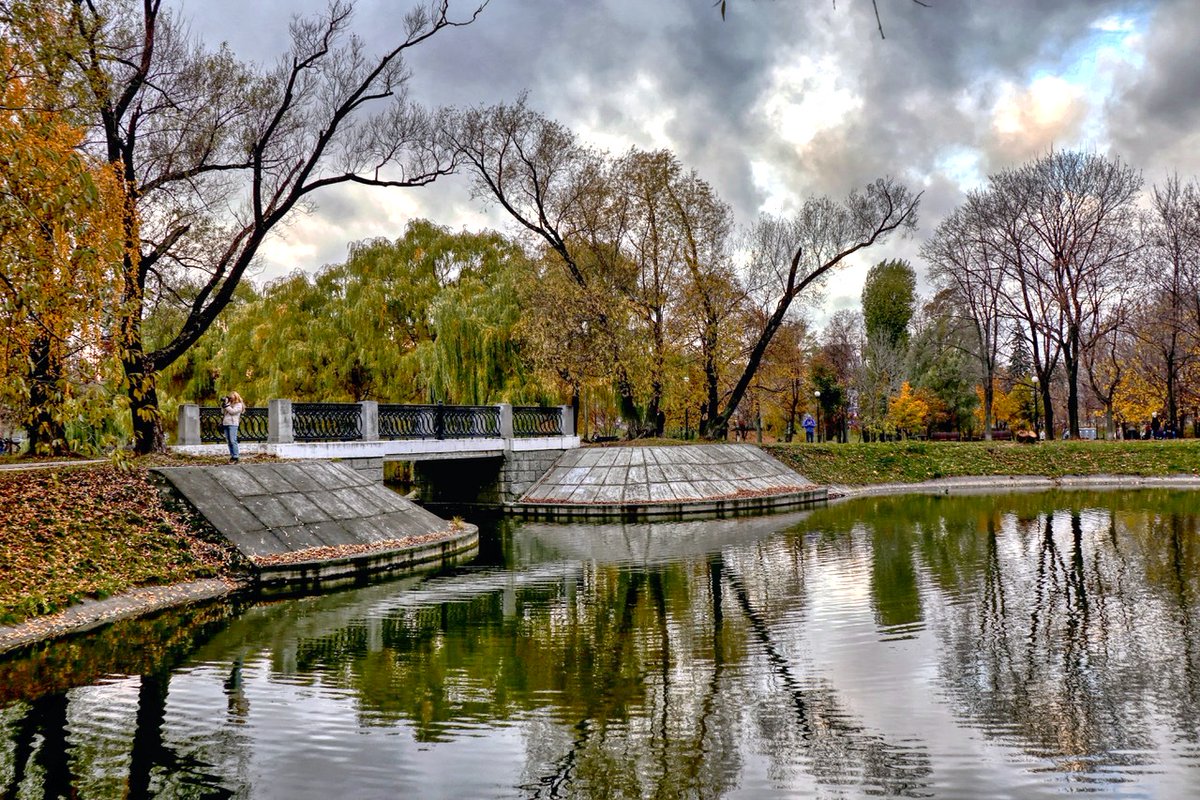 PEKHTography's tweet image. Leaves drift like suspended thoughts; a bridge hums with quiet secrets — time bends, and you feel it slipping through your fingers. 🍁🌉 #AutumnVibes #UrbanNature #MelancholicBeauty