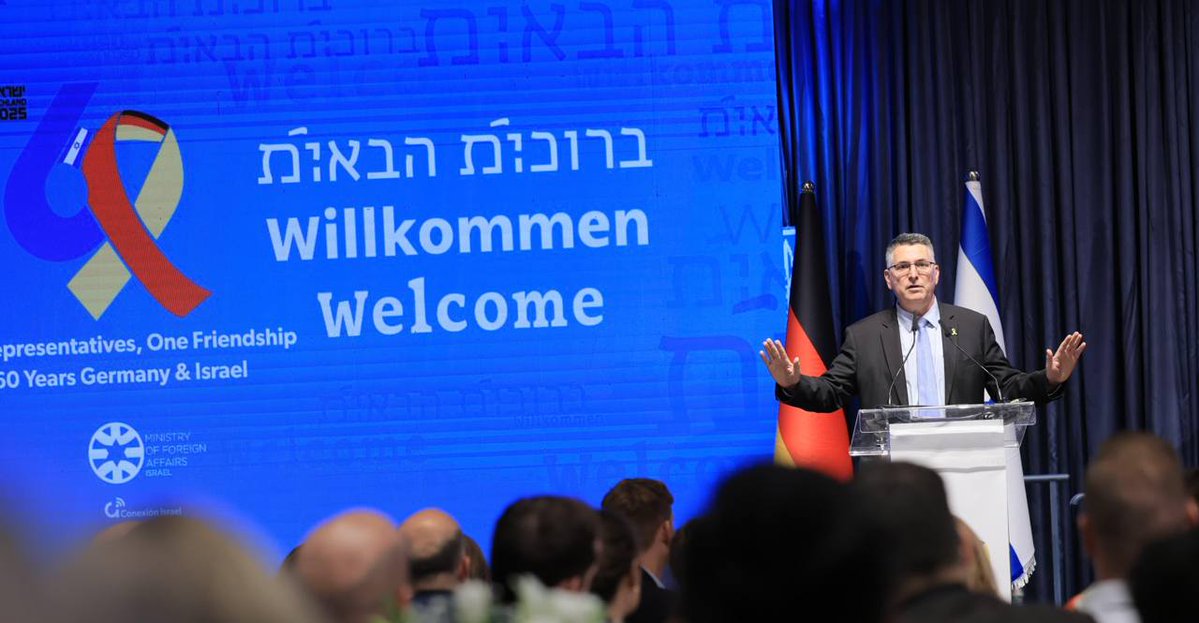 השר <a href="/gidonsaar/">Gideon Sa'ar | גדעון סער</a> נאם היום בפני קבוצת מנהיגים צעירים מגרמניה, ליד שלט "ברוכים הבאים" באנגלית, בגרמנית, ובעוד שפה בלתי מזוהה, שמזכירה עברית אך הושחתה ללא היכר ע"י וירוס מוח פרוגרסיבי.

על סמל יהודי כלשהו אין מה לדבר, כי סרט האיתות המוסרי תופס את המקום המרכזי - מלבד דגלון ישראל זערורי