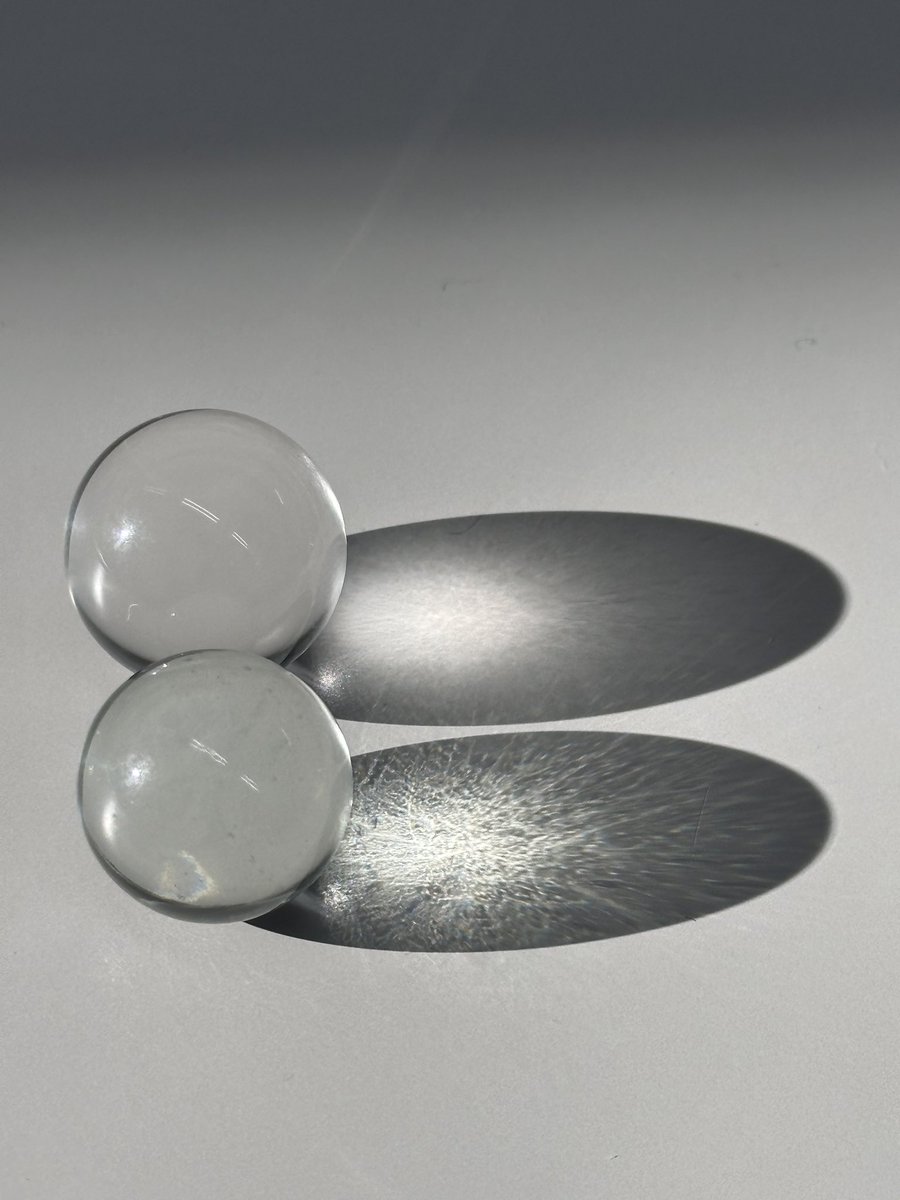 机の上で水晶玉とガラス玉を並べてたら、ちょうど日がさしてきたんだ。
上：水晶
下：ガラス