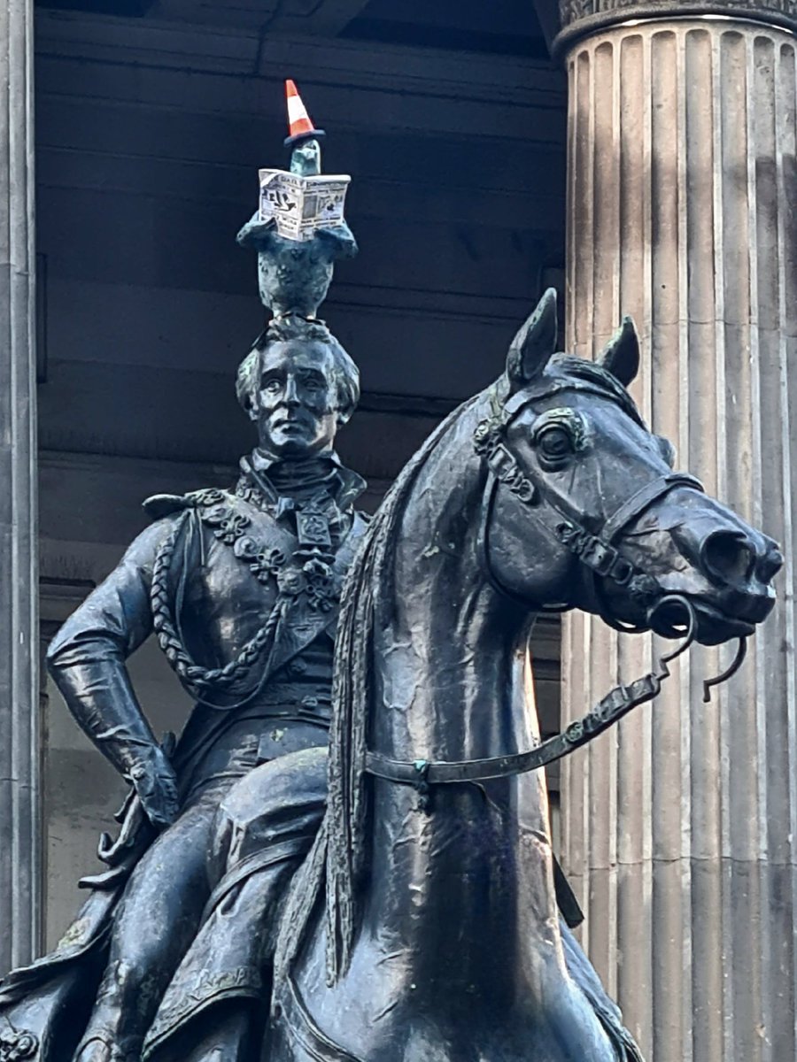 is_glasgow's tweet photo. The Duke of Wellington statue on Queen Street in Glasgow this morning, with a new take on the traditional road cone by The Rebel Bear. What you can't see from this shot is that the pigeon is doing what pigeons usually do on statues!

#glasgow #glasgowtoday #streetart https://t.co/hSbSRY6GmU