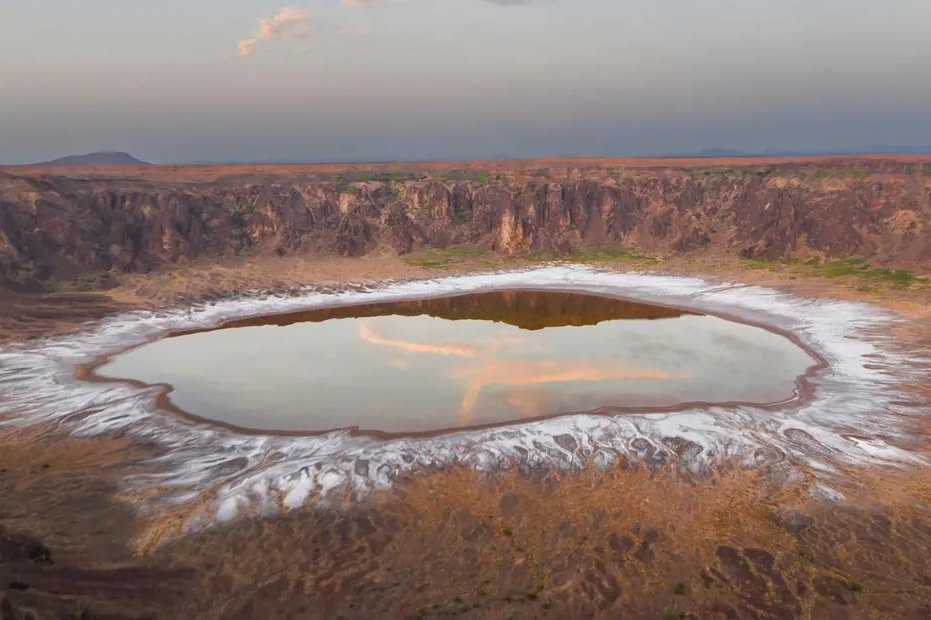 بحيرة #طمية شمال شرقي الطائف تحفة جيولوجية تتوسط فوهة بركانية ضخمة ضمن حرة كشب، تحيط بها جدران صخرية داكنة تشكّلت بفعل نشاط بركاني قديم. مشهد نادر يجسّد تاريخ الأرض وتحولاتها عبر آلاف السنين. 🌋✨