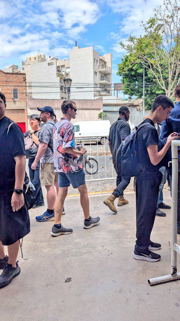 Vitalik Buterin walking into ETH Day 2025 wearing a colorful Moodeng hippo shirt and sunglasses