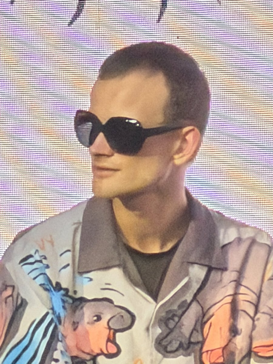Close-up of Vitalik Buterin in Moodeng shirt and oversized sunglasses